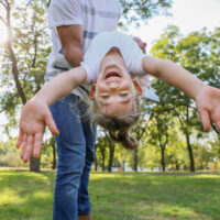 Child enjoying springtime weather outside with her dad